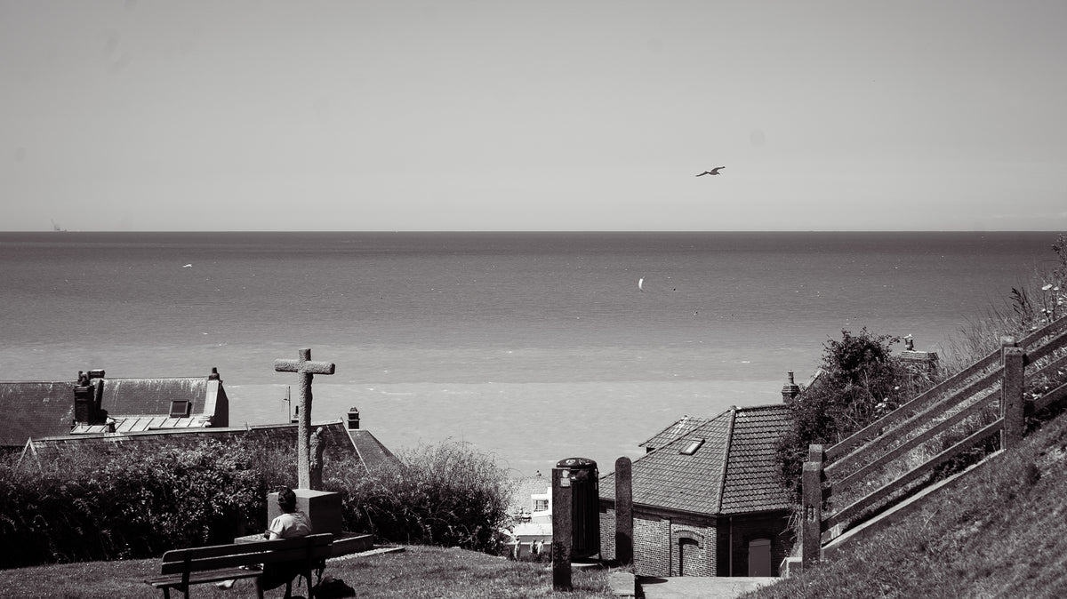 Calvaire et toits de Mers-les-Bains face à la mer, mouette dans le ciel - photographie noir et blanc - Corentin GMT