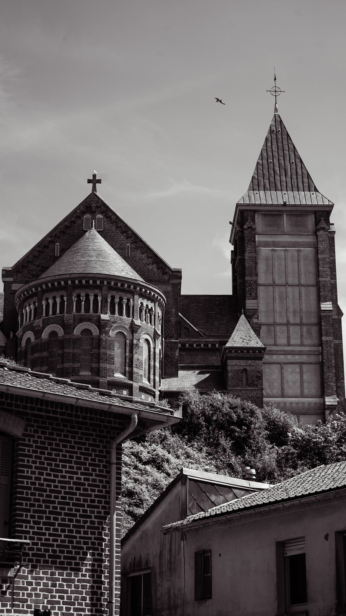 Église en brique et clocher pointu dominant les toits de Mers-les-Bains - photographie noir et blanc - Corentin GMT