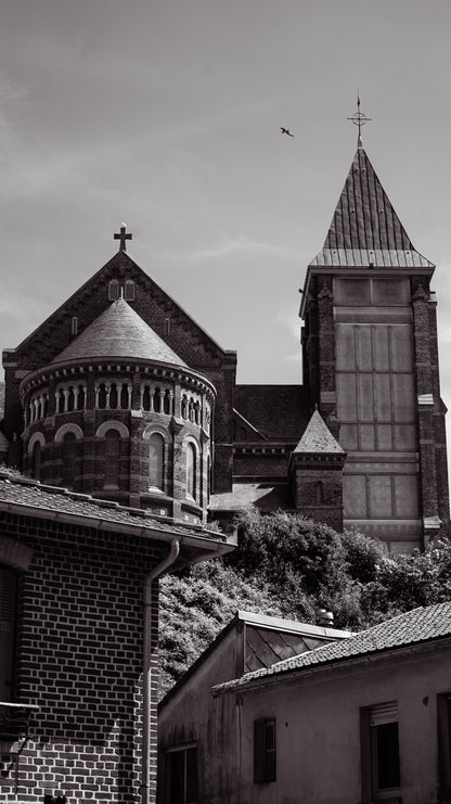 Église en brique et clocher pointu dominant les toits de Mers-les-Bains - photographie noir et blanc - Corentin GMT
