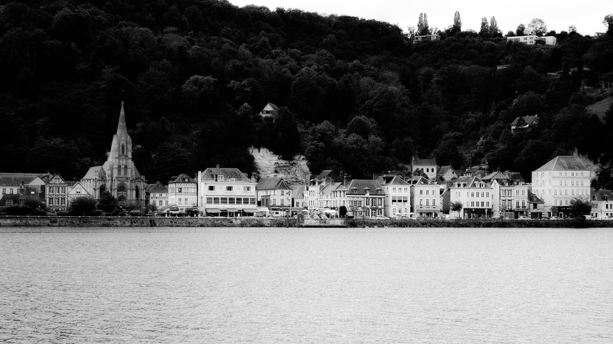 Village de La Bouille, église et façades au pied du coteau boisé au bord de la Seine - photographie N&B - Corentin GMT
